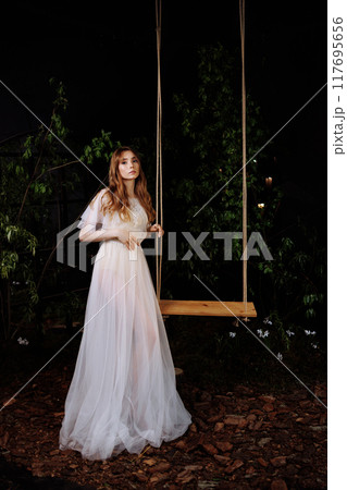 Elegant woman on wooden swing. 117695656
