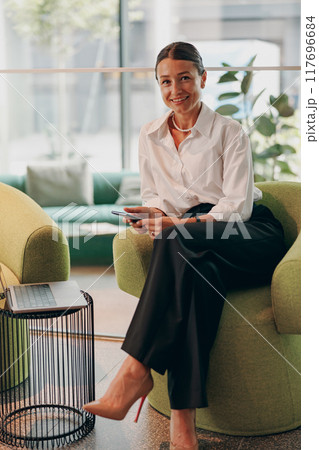 An Elegant Business Professional in a Modern and WellDesigned Workspace Setting An Elegant Business Professional in a Modern and WellDesigned Workspace Setting 117696684
