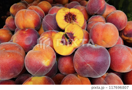 Ripe juicy peaches close-up at a market, natural fruit background Ripe juicy peaches close-up at a market, natural fruit background 117696807