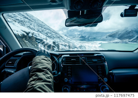 Driving off road car on snowing high altitude mountain trail on winter day 117697475