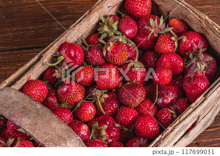 ripe strawberries in a wooden box on the table close up ripe strawberries in a wooden box on the table close up 117699031