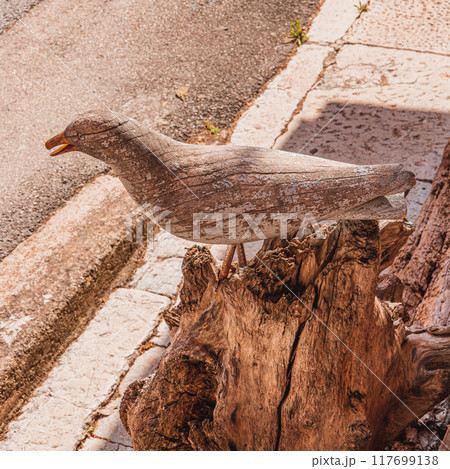 A wooden sculpture of a seagull on a stump Vrsar Croatia 08.07.24 117699138