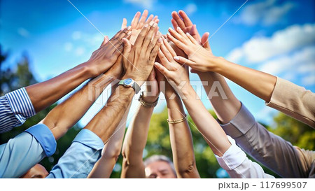 A diverse group of hands interlock, representing unity and a shared commitment to achieving a common goal. 117699507