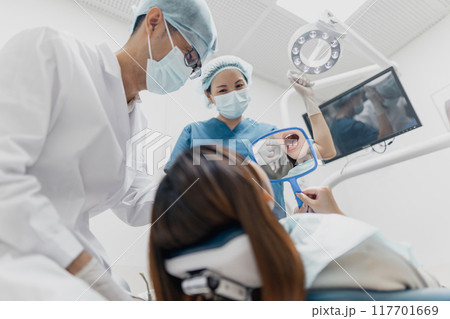 Asian dental professionals provide oral care and service to a female patient 117701669