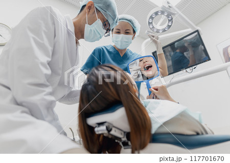 Asian dental professionals provide oral care and service to a female patient 117701670