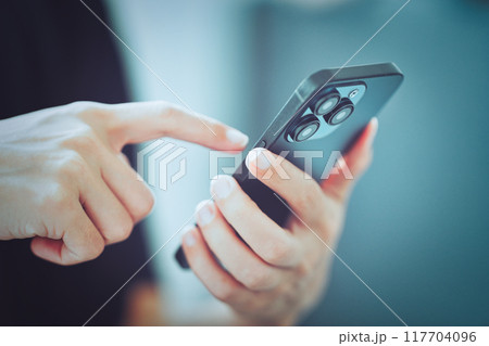 スマホを利用する女性の手元 117704096