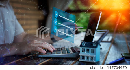 Budget and financial planning concept. Businessman analyzing investment charts with calculator and laptop. Double exposure. 117704470