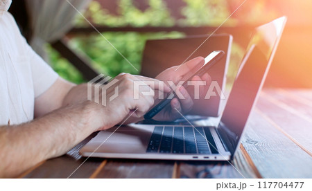 A man adds items to his cart while shopping in an international online store. E-commerce marketing offers discounts and free home delivery from any country. 117704477