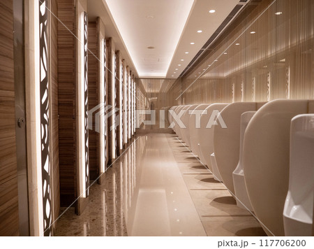 Modern public restroom with sleek white urinals and elegant lighting at night Modern public restroom with sleek white urinals and elegant lighting at night 117706200