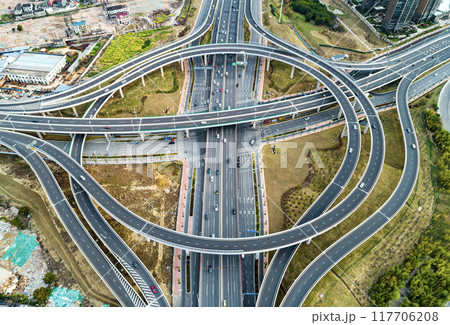 Aerial view of complex highway interchange surrounding lush greenery in daylight Aerial view of complex highway interchange surrounding lush greenery in daylight 117706208
