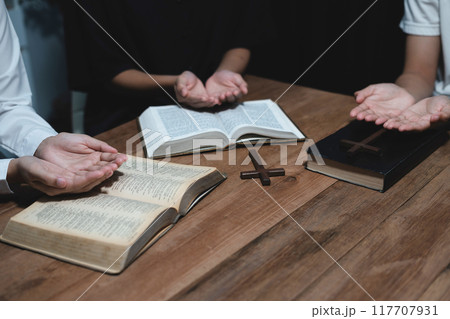 Asian men and women hands praying to god with the bible. Pray for god blessing. Religious beliefs Christian life crisis prayer to god. 117707931