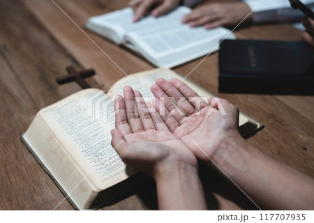 Asian men and women hands praying to god with the bible. Pray for god blessing. Religious beliefs Christian life crisis prayer to god. 117707935