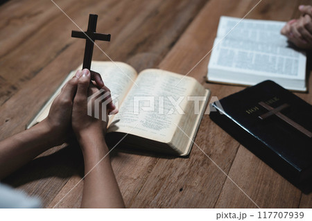 Asian men and women hands praying to god with the bible. Pray for god blessing. Religious beliefs Christian life crisis prayer to god. Asian men and women hands praying to god with the bible. Pray for god blessing. Religious beliefs Christian life crisis prayer to god. 117707939