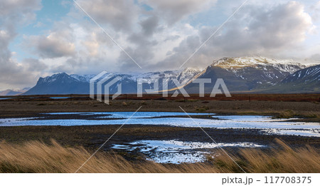 View during auto trip in West Iceland highlands, Snaefellsnes peninsula, Snaefellsjokull National Park. Spectacular volcanic tundra landscape with mountains, craters, lakes, gravel roads. 117708375