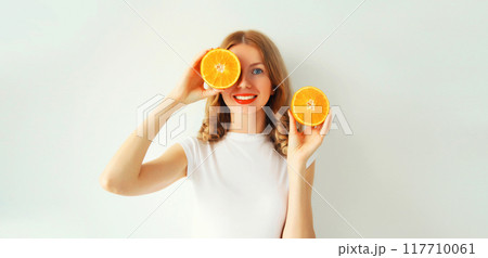 Summer, nutrition, diet concept. Happy healthy smiling young woman with slices of orange fruits 117710061