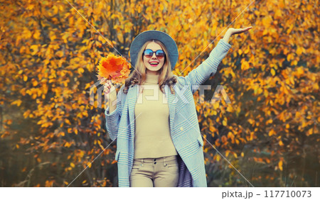 Autumn portrait of beautiful happy smiling woman with yellow maple leaves in the park Autumn portrait of beautiful happy smiling woman with yellow maple leaves in the park 117710073
