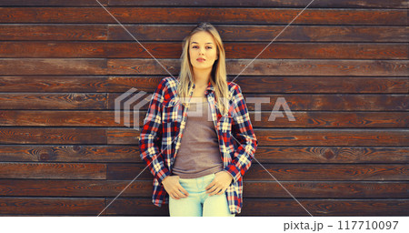 Portrait of beautiful caucasian blonde young woman in casual checkered shirt in the city Portrait of beautiful caucasian blonde young woman in casual checkered shirt in the city 117710097