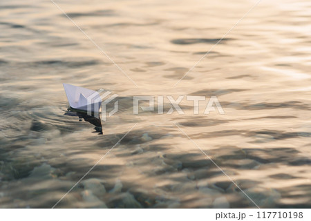 Origami white paper boat on blue deep water. 117710198