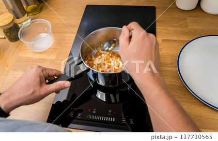 Chef at the kitchen preparing healthy quinoa bowl with avocado 117710565