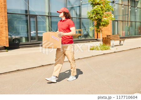 Delivery person wearing red uniform holding cardboard package labeled Express 117710604