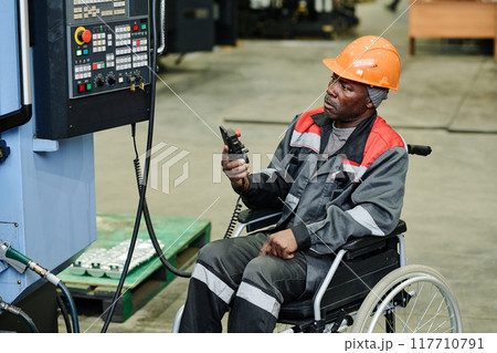 Operating Industrial Equipment from Wheelchair in Factory Operating Industrial Equipment from Wheelchair in Factory 117710791