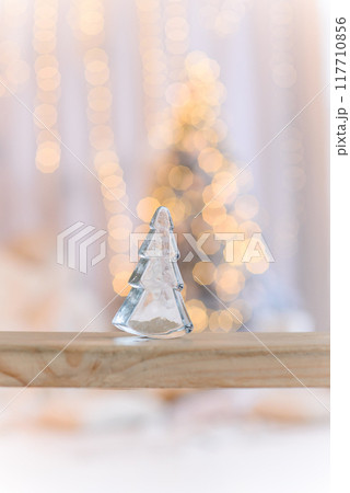 Close up transparent Christmas tree made of glass stands on a wooden swing. Christmas background. 117710856