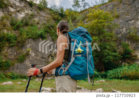 A Hiker Enthusiastically Enjoying the Beauty of Nature with a Backpack and Trekking Poles A Hiker Enthusiastically Enjoying the Beauty of Nature with a Backpack and Trekking Poles 117710923