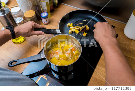 Chef at the kitchen preparing pumpkin porridge with tofu and vegetables 117711395
