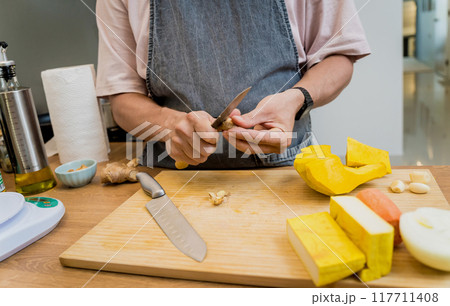 Chef at the kitchen preparing pumpkin porridge with tofu and vegetables 117711408