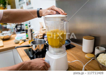 Chef at the kitchen preparing pumpkin porridge with tofu and vegetables 117711409