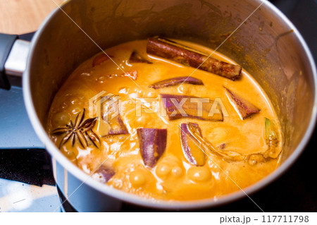 Chef at the kitchen preparing massaman curry with sweet potato and many spices Chef at the kitchen preparing massaman curry with sweet potato and many spices 117711798