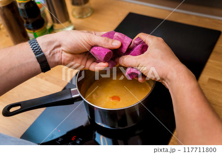 Chef at the kitchen preparing massaman curry with sweet potato and many spices Chef at the kitchen preparing massaman curry with sweet potato and many spices 117711800