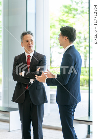 オフィスのロビーで会話する上司と部下 オフィスのロビーで会話する上司と部下 117712854