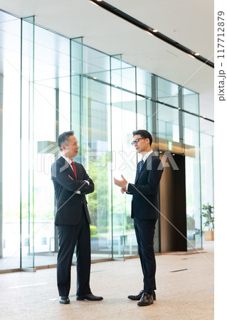 オフィスのロビーで会話する上司と部下 オフィスのロビーで会話する上司と部下 117712879
