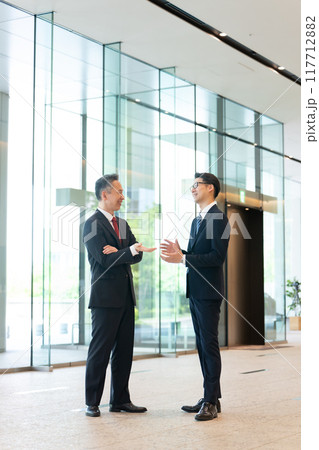 オフィスのロビーで会話する上司と部下 オフィスのロビーで会話する上司と部下 117712882