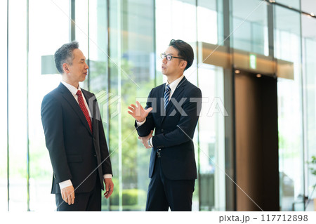 オフィスのロビーで会話する上司と部下 オフィスのロビーで会話する上司と部下 117712898