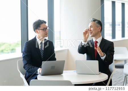 ラウンジで打ち合わせするビジネスマン 117712933