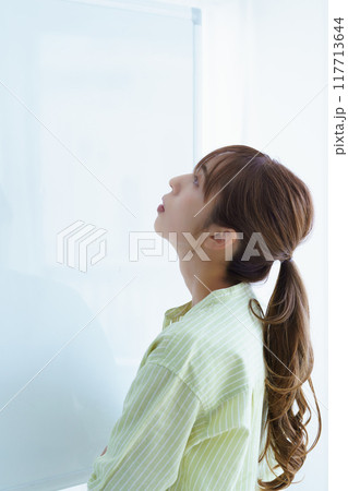 オフィスで課題を見える化する若い女性 117713644