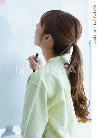 オフィスで課題を見える化する若い女性 オフィスで課題を見える化する若い女性 117713645