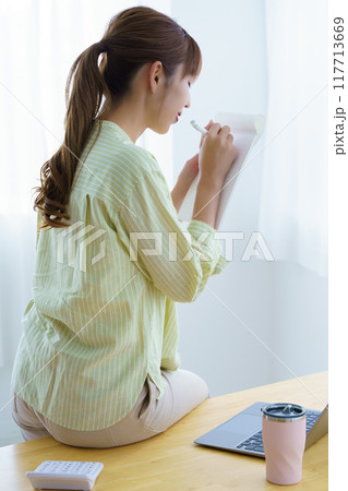 オフィスで起業の準備をする若い女性 117713669