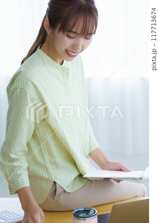 オフィスで起業の準備をする若い女性 117713674