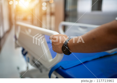 A person is holding a hospital bed handle and wearing a watch 117713961