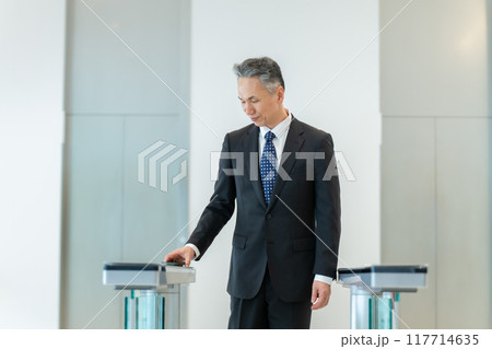 IDをかざすビジネスマン 117714635