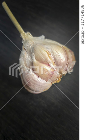 Garlic on dark background for cooking home food. Useful antibacterial product. Garlic on dark background for cooking home food. Useful antibacterial product. 117714936