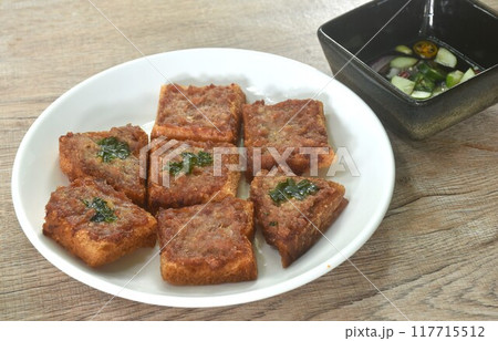 Thai crispy fried pork toast on plate eat couple with pickled vegetable sauce 117715512