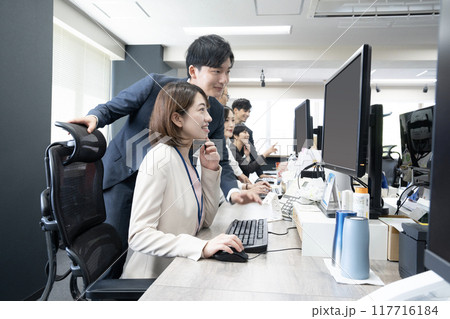 オフィースでパソコンに向かって仕事をする6名のスタッフ 117716184