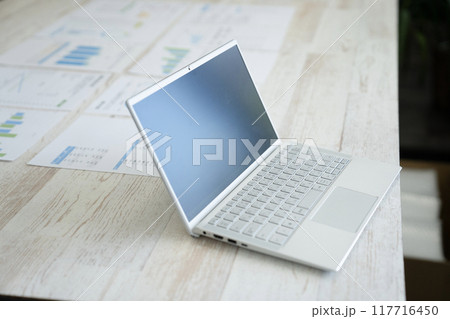 デスクの上のノートパソコンと資料 117716450