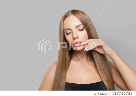 Lovely female model brunette with long hair and natural make-up posing isolated on white background Lovely female model brunette with long hair and natural make-up posing isolated on white background 117716725