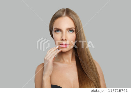 Attractive female model brunette with long hair and natural make-up posing isolated 117716741