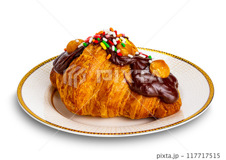 Croissant garnished with chocolate and rainbow sprinkles. 117717515